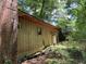 Side exterior view of a rustic home featuring a brick chimney and natural landscaping at 195 Darla Dr, Woodstock, GA 30188