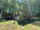 Two-story cabin-style home with covered porches surrounded by green vegetation at 195 Darla Dr, Woodstock, GA 30188