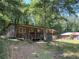 Cabin-style home with a wooden porch and surrounded by trees and vegetation at 195 Darla Dr, Woodstock, GA 30188