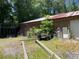 Side view of outbuilding with rusted door and equipment at 195 Darla Dr, Woodstock, GA 30188