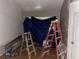 A bare room is shown, with a blue tarp covering the window and two ladders in the shot at 195 Darla Dr, Woodstock, GA 30188