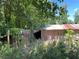 Exterior shot of the storage building surrounded by dense vegetation at 195 Darla Dr, Woodstock, GA 30188