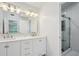 Bright bathroom featuring dual sinks, white cabinets, and a glass-enclosed shower at 2268 Orleans Ave, Marietta, GA 30062
