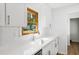 Bright kitchen features white cabinets, quartz countertops and modern sink and faucet at 3031 Walker Dr, Marietta, GA 30062