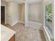 Bright bathroom featuring a soaking tub, a walk-in shower, and neutral-toned flooring at 6240 Shenfield Ln, Union City, GA 30291