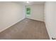 This bedroom features neutral paint and carpet plus a window view of the outdoors at 6240 Shenfield Ln, Union City, GA 30291