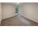 This bedroom has neutral paint and carpet plus a window view of the outdoors at 6240 Shenfield Ln, Union City, GA 30291