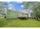 Backyard view showcasing a wooden deck and green lawn under a blue sky at 1249 Riva Ridge Dr, Norcross, GA 30093
