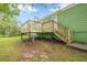 A newly constructed backyard deck and stairs with wooden railings lead to a green home with an ample lawn and trees at 1249 Riva Ridge Dr, Norcross, GA 30093