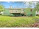 Backyard view of a green home with a wooden deck, stairs, and air conditioning unit at 1249 Riva Ridge Dr, Norcross, GA 30093