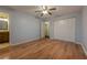 Spacious bedroom with light blue walls, hardwood floors, ceiling fan, and closet doors at 1249 Riva Ridge Dr, Norcross, GA 30093
