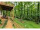 Backyard with a gravel path leading to a lush green forest from under the deck offering scenic views at 2880 Foothill Trl, Marietta, GA 30066