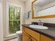 Bathroom featuring a wood vanity, an oval sink and a window with a view of a lush treeline at 2880 Foothill Trl, Marietta, GA 30066