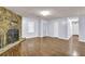 Bright living room featuring hardwood floors, a stone fireplace and a back door at 5012 Galbraith Cir, Stone Mountain, GA 30088
