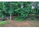 Landscaped backyard with mature trees and a wooden fence for added privacy at 121 Paradise Circle, Douglasville, GA 30134