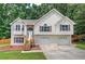 Charming split-level home featuring stone accents, wood shutters, and a two-car garage at 121 Paradise Circle, Douglasville, GA 30134