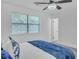 Bright bedroom features a ceiling fan, plush bedding, and natural light from the window at 3706 Londonderry Ct, Lithonia, GA 30038