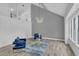 Bright and airy living room featuring modern lighting fixtures, wood-look floors, and cozy blue armchairs at 3706 Londonderry Ct, Lithonia, GA 30038