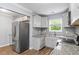 Well-equipped kitchen featuring stainless steel appliances, gray cabinets, granite countertops and a window above the sink at 856 Bridgewater Sw St, Atlanta, GA 30310