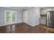 Living area with stainless steel refrigerator, access to covered porch, hardwood floors, and light-colored walls at 856 Bridgewater Sw St, Atlanta, GA 30310