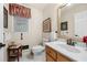 Bathroom featuring a white toilet and sink with wood cabinets, and a framed mirror at 2214 Trilleck Nw Dr, Kennesaw, GA 30152