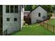 Beautiful home exterior showing brick facade, grassy yard, black fencing, and wooded surroundings at 313 Anderwood Rdg, Marietta, GA 30064