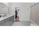 Modern bathroom featuring stylish gray vanity, walk-in closet, and elegant black and white patterned tile flooring at 313 Anderwood Rdg, Marietta, GA 30064