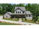 Elegant two-story home with lush landscaping, a gray roof, and a welcoming porch at 313 Anderwood Rdg, Marietta, GA 30064