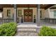 Charming brick home featuring a cozy front porch, double front doors with wreaths, and beautiful landscaping at 313 Anderwood Rdg, Marietta, GA 30064