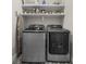 Functional laundry area showcasing modern washer and dryer, built-in shelving, and patterned tile flooring at 313 Anderwood Rdg, Marietta, GA 30064