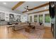 Open-concept living room featuring wood floors, beamed ceilings, a fireplace, and a view to the gourmet kitchen at 313 Anderwood Rdg, Marietta, GA 30064