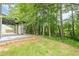 A grassy backyard with mature trees, and a spacious porch, creating a private outdoor retreat at 4959 Abbotts Glen, Acworth, GA 30101
