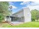 Landscaped backyard showcasing a porch area, lush greenery, and the home's exterior under a bright sky at 4959 Abbotts Glen, Acworth, GA 30101