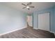 Bedroom featuring light blue walls, wood floors, a window, closet, and a ceiling fan at 4959 Abbotts Glen, Acworth, GA 30101
