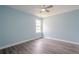 Bedroom with light blue walls, hardwood floors, a ceiling fan, and a large window at 4959 Abbotts Glen, Acworth, GA 30101