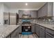 Updated kitchen with granite countertops, stainless steel appliances, gray cabinets, and a center island at 4959 Abbotts Glen, Acworth, GA 30101