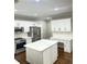 Spacious kitchen featuring white cabinets, stainless appliances, hardwood floors, and an island with countertop at 540 Langley Creek Dr, Loganville, GA 30052