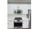 Kitchen with stainless steel appliances, white cabinetry, and modern finishes at 540 Langley Creek Dr, Loganville, GA 30052