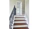 Staircase with hardwood treads, white risers, and dark metal railing with decorative spindles at 540 Langley Creek Dr, Loganville, GA 30052