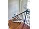 Elegant staircase featuring hardwood steps, a decorative wrought iron railing, and a modern sphere chandelier at 540 Langley Creek Dr, Loganville, GA 30052