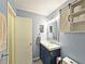 Bathroom featuring a stylish blue vanity and a decorative sliding barn door cabinet at 1202 Countryside Pl, Smyrna, GA 30080
