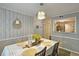 Well-lit dining area with modern light fixture, stylish wallpaper, and an adjacent view of the kitchen at 1202 Countryside Pl, Smyrna, GA 30080