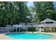 Community swimming pool with sun loungers, decks, and a clubhouse surrounded by lush greenery and natural beauty at 1202 Countryside Pl, Smyrna, GA 30080