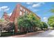 A wide shot of the exterior of the building showing a red brick exterior and large windows underneath a cloudy blue sky at 170 Boulevard Se # E120, Atlanta, GA 30312