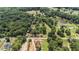 Aerial view showcasing the property's large acreage, surrounding trees, and proximity to a pond at 677 Panola Rd, Ellenwood, GA 30294