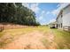 Expansive backyard with wooden fence backing up to lush trees, and a covered porch at 93 Oakdale Way, Temple, GA 30179