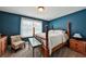 A primary bedroom painted a vibrant blue hue, complemented by carpet flooring and warm lighting at 93 Oakdale Way, Temple, GA 30179