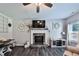 Charming living room featuring a stone fireplace, entertainment center, and lots of natural light at 93 Oakdale Way, Temple, GA 30179