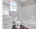 This well lit bathroom features a tub, shower, vanity and window with neutral walls at 800 Tradd Ct, Stone Mountain, GA 30087