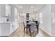 Modern dining area adjacent to a kitchen featuring white cabinets and black accents at 1349 Lockhaven Sw Cir, Atlanta, GA 30311